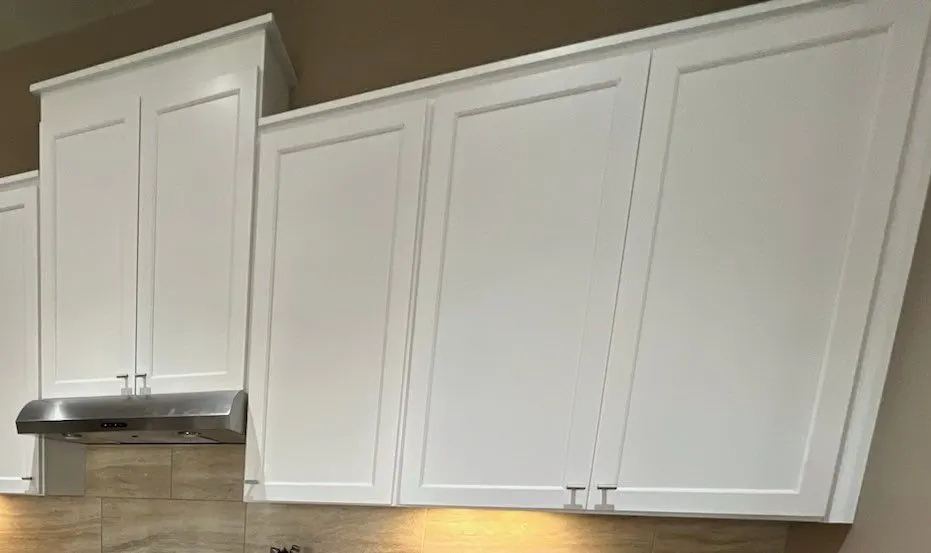 The same upper cabinets painted white