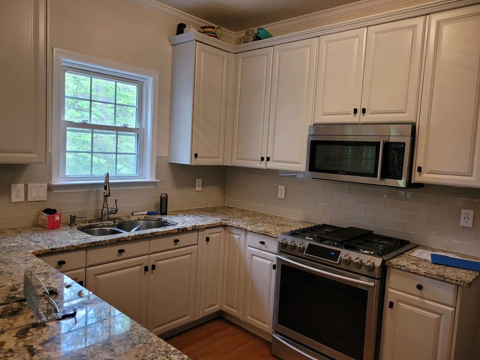 Kitchen with cream painted cabinets around a window