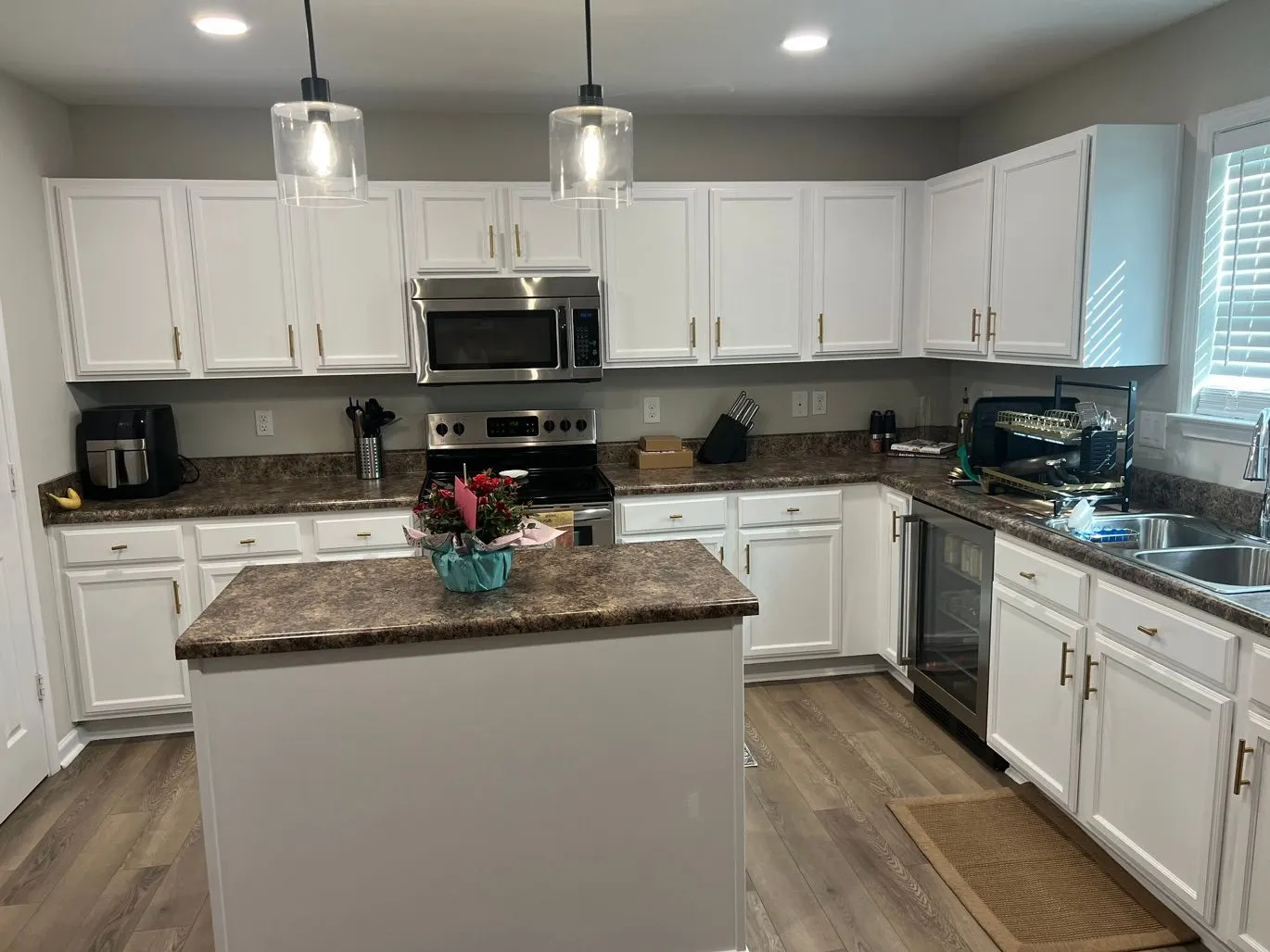 White painted kitchen cabinets and island with pendant lights