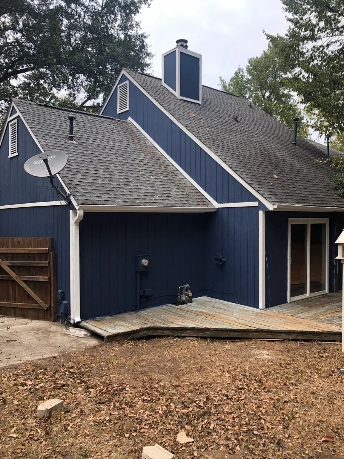 Back of a house painted navy blue with a new deck