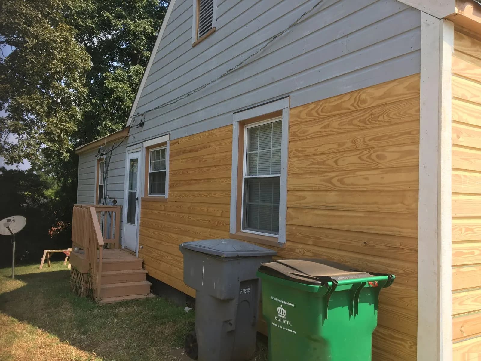 New wood siding boards installed on the side of a house before painting