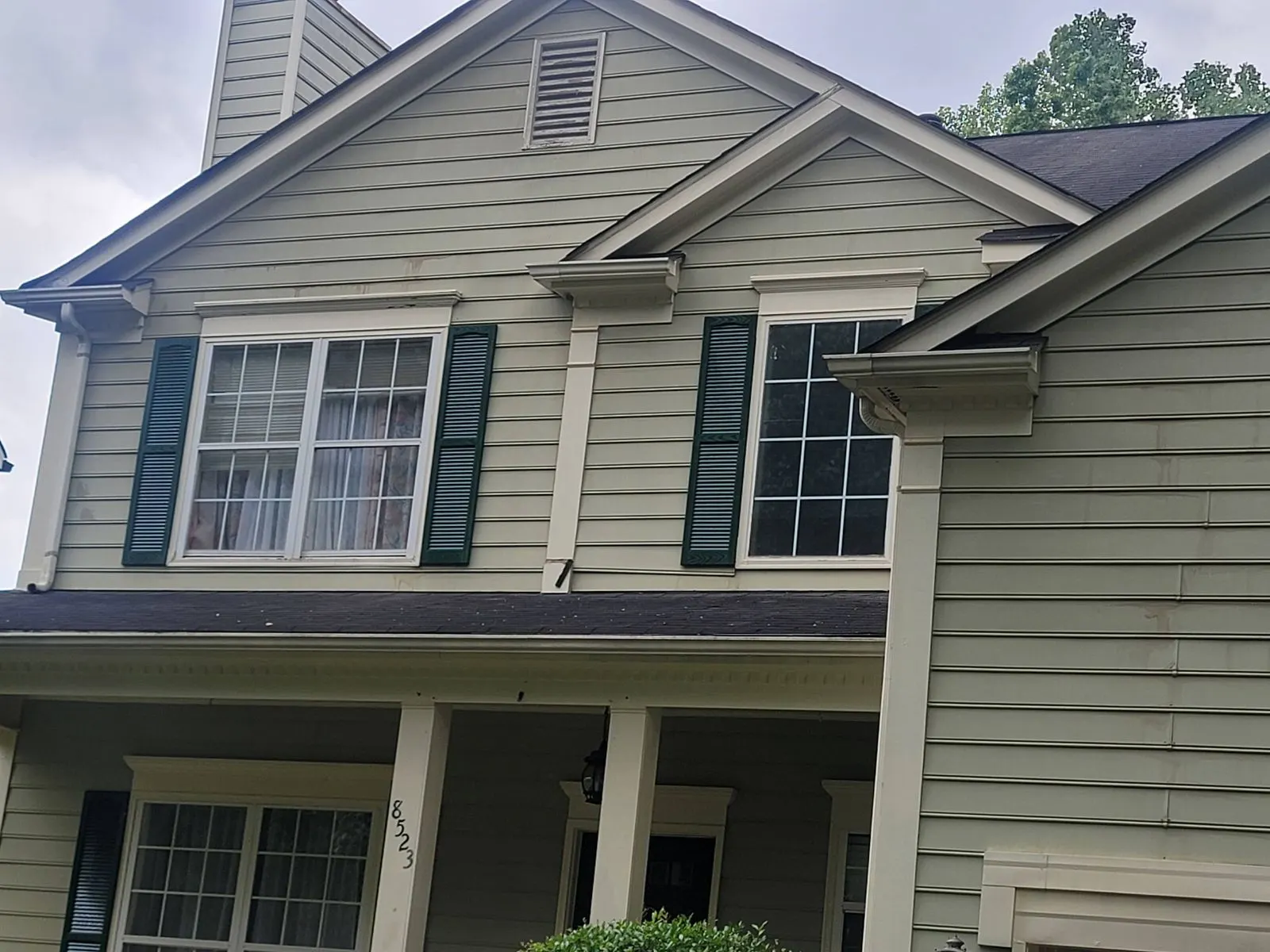 Sage green siding with dark green shutters and white trim