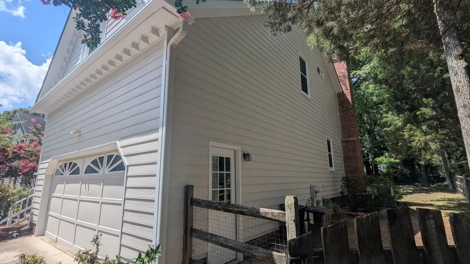 Side of a white house with a garage and dentil trim